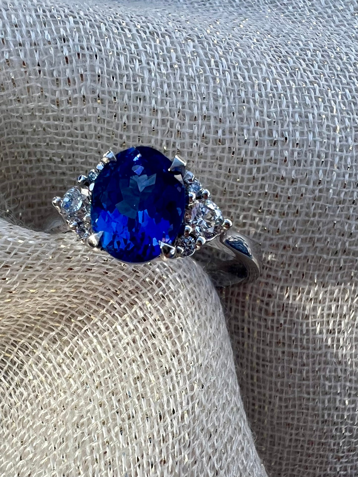Oval Tanzanite with cluster of side diamonds.