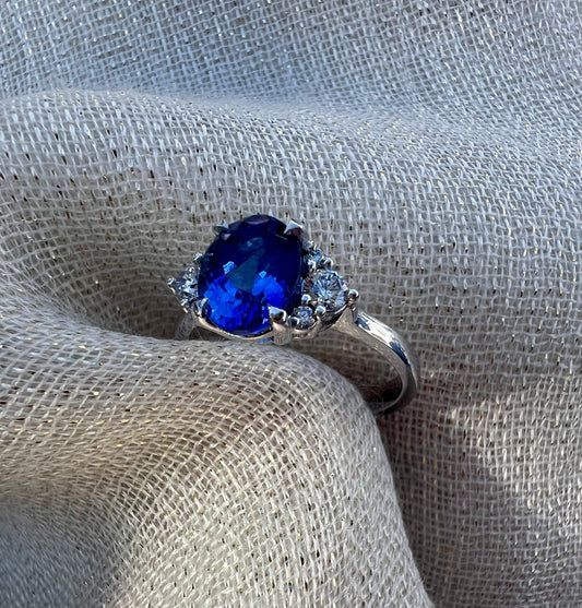 Oval Tanzanite with cluster of side diamonds.